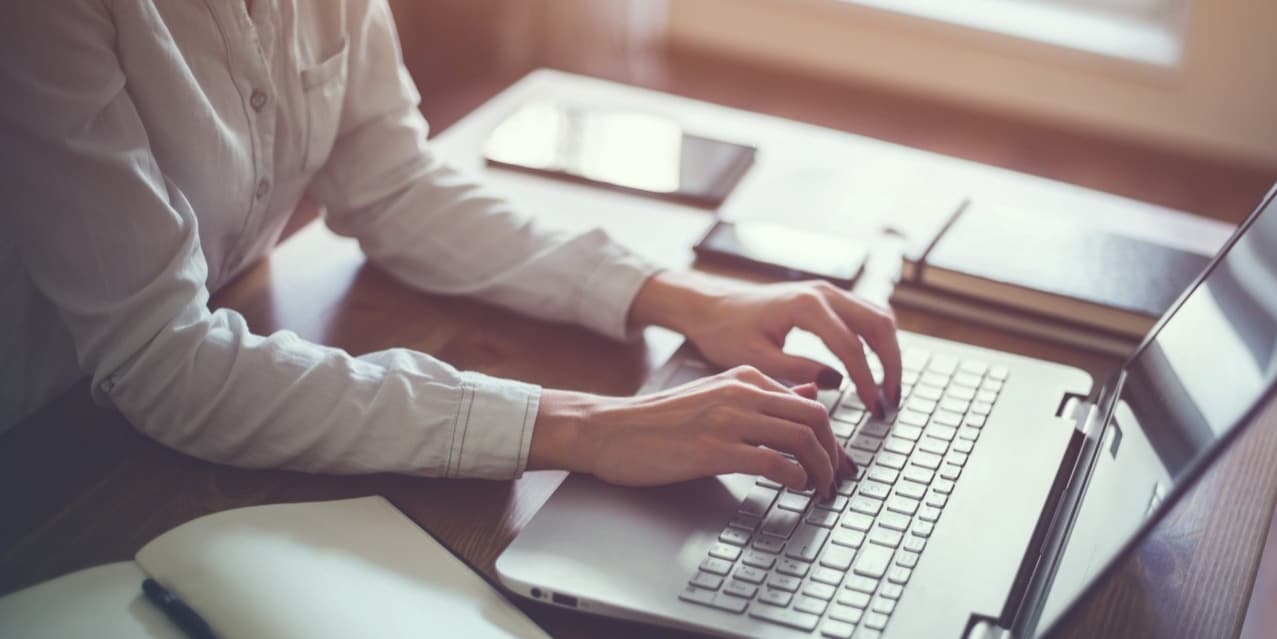 Person writing on laptop